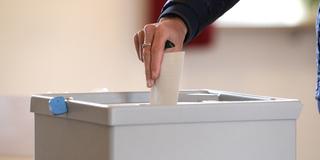 Wähler bei der Stimmabgabe an einer Wahlurne (Foto: IMAGO / Eibner)
